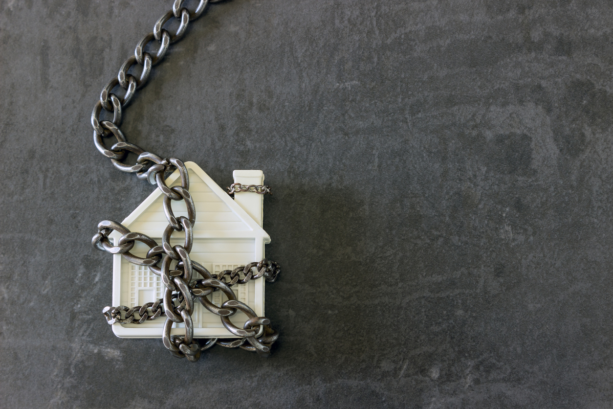 House in chains. Concept - risks, lose property, seize, mortgage.